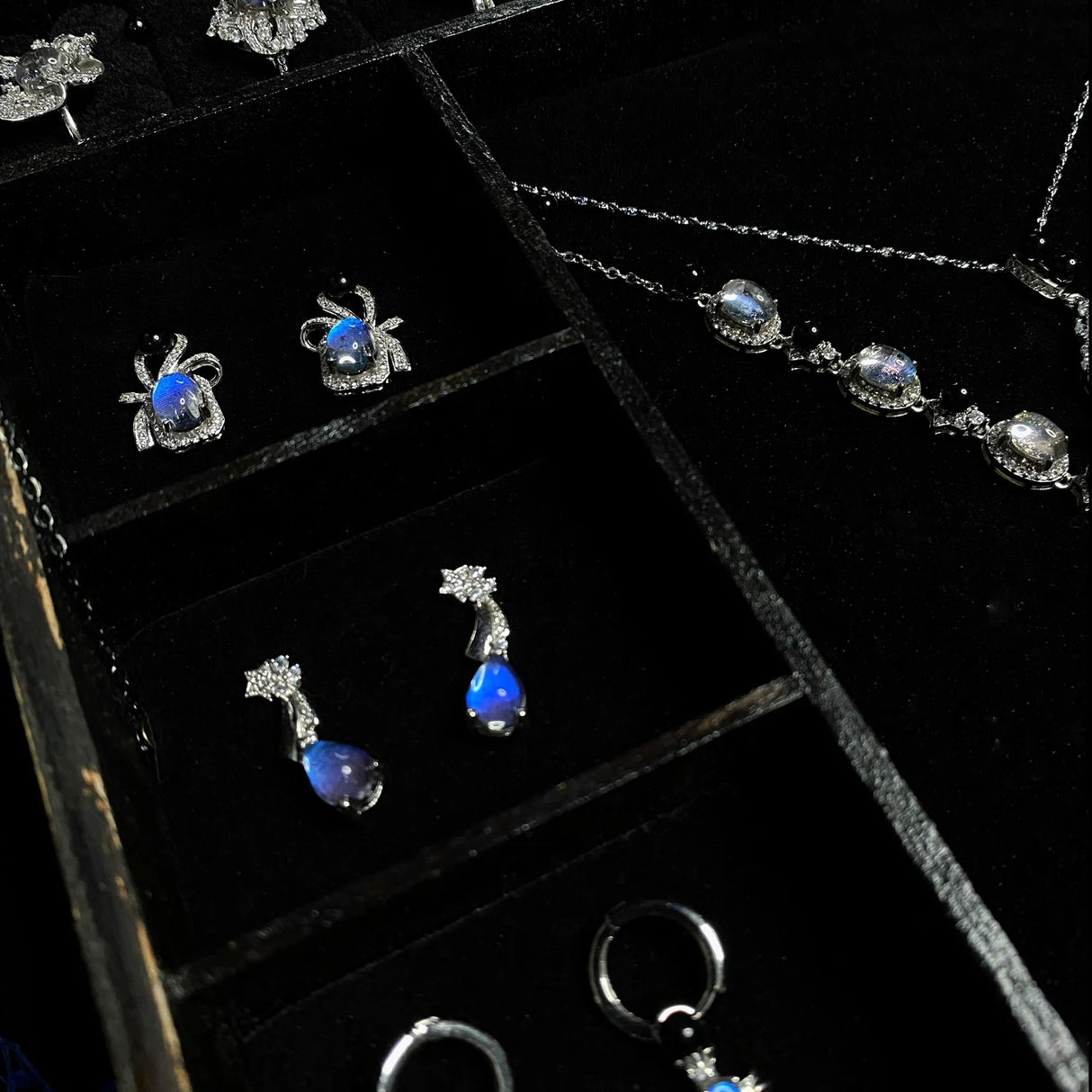 Earring storage section featuring handcrafted Blue Morpho butterfly wing earrings inside a luxury jewelry box.