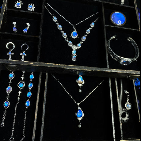 Interior view of a Blue Morpho butterfly jewelry box featuring velvet-lined compartments and handmade butterfly wing jewelry.