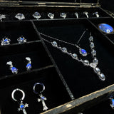 Real preserved Morpho helena butterfly mounted inside a luxury jewelry box with vivid iridescent blue wings.